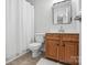 This is a bathroom with a wood vanity, framed mirror, tile floor, and shower with white curtain at 14649 Lions Paw St, Charlotte, NC 28273