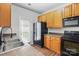 Functional kitchen features a sink, range, microwave, refrigerator, brown cabinets and dark countertop at 14649 Lions Paw St, Charlotte, NC 28273