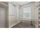 Spacious walk-in closet with custom shelves, rods, carpet, and a cozy window seat at 14649 Lions Paw St, Charlotte, NC 28273
