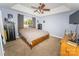 Comfortable bedroom with neutral carpet, tray ceiling, ceiling fan, and a wooden bed frame at 1556 Berkshire Dr, Newton, NC 28658