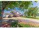 Spacious home with an attached garage, expansive driveway, and mature trees, offering privacy and ample parking at 1556 Berkshire Dr, Newton, NC 28658