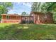 Brick ranch style home featuring a wooden deck and lush green yard, set in a beautiful tree lined back yard at 182 Freedom Mill Rd, Gastonia, NC 28052