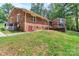 Brick ranch style home featuring a wooden deck, walkout basement, and lush green yard at 182 Freedom Mill Rd, Gastonia, NC 28052