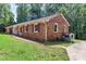 Brick ranch home with red shutters, a well-maintained lawn, and an air conditioning unit on the side at 182 Freedom Mill Rd, Gastonia, NC 28052