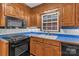Classic kitchen showcases wood cabinets, black appliances, and a window over the sink at 182 Freedom Mill Rd, Gastonia, NC 28052