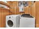 Laundry room with washer, dryer, wooden walls and storage shelves at 182 Freedom Mill Rd, Gastonia, NC 28052