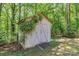 Outdoor storage shed with vines climbing up the side surrounded by lush greenery and mature trees at 182 Freedom Mill Rd, Gastonia, NC 28052