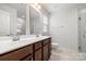 Bathroom featuring a double sink vanity, tile floor, mirrors, white toilet, and shower with glass doors at 1933 Tin Roof Ln, Monroe, NC 28112