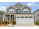 Charming two-story home featuring gray siding, white trim, manicured landscaping, and an attached two-car garage at 1933 Tin Roof Ln, Monroe, NC 28112