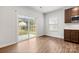 Eat-in kitchen featuring hardwood flooring, sliding glass doors, modern cabinets, stainless steel microwave, and white subway tile backsplash at 1933 Tin Roof Ln, Monroe, NC 28112