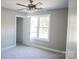 Bright bedroom with neutral walls, a ceiling fan, and a view of a window with a tree at 200 N Kayla Dr, Salisbury, NC 28146