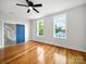Bright bedroom features hardwood floors, fresh white walls, blue closet door, and a ceiling fan at 217 S Green St, Wadesboro, NC 28170