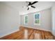 Bright bedroom features hardwood floors, ceiling fan, and two windows overlooking the front yard at 217 S Green St, Wadesboro, NC 28170