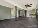 Spacious deck with covered ceiling, ceiling fan, dark stained floors and siding, and sliding glass doors at 217 S Green St, Wadesboro, NC 28170