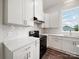 Bright kitchen featuring white cabinetry, quartz countertops, stainless steel appliances, and a designer backsplash at 217 S Green St, Wadesboro, NC 28170
