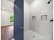 Modern shower featuring white herringbone tile, a rain shower head, and recessed shelving for toiletries at 217 S Green St, Wadesboro, NC 28170