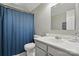 A well-lit bathroom with a blue shower curtain, single sink vanity, and modern faucet at 2224 Clonmel Pl, Charlotte, NC 28262