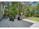 Outdoor deck with seating, fire pit, and surrounding trees create a perfect relaxing retreat at 2224 Clonmel Pl, Charlotte, NC 28262