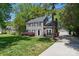 Two-story home with gray siding, black shutters, and a detached garage, providing ample parking and storage at 2224 Clonmel Pl, Charlotte, NC 28262