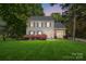 Charming two-story home featuring gray siding, black shutters, and a well-manicured lawn under an enchanting evening sky at 2224 Clonmel Pl, Charlotte, NC 28262