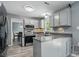 Well-lit kitchen featuring modern appliances, gray cabinets, durable floors, and views into the dining area at 2224 Clonmel Pl, Charlotte, NC 28262