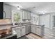 Bright kitchen with stainless steel appliances, neutral cabinets and countertops, and modern lighting fixtures at 2224 Clonmel Pl, Charlotte, NC 28262