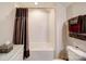 White bathroom includes a tub with shower, tiled walls, and a storage cabinet at 2306 Wesley Landing Rd, Waxhaw, NC 28173