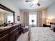 Serene bedroom with large dresser and mirror, a window seat, and hardwood furniture at 2306 Wesley Landing Rd, Waxhaw, NC 28173
