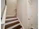 Classic staircase with hardwood treads, white risers, and a stylish white railing at 2306 Wesley Landing Rd, Waxhaw, NC 28173