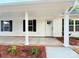 Inviting front porch view with a white door, black shutters, and garden beds at 288 Tram Rd, Lancaster, SC 29720