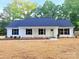 Charming single-story home with a blue roof, white siding, black shutters, and a freshly mulched front yard at 288 Tram Rd, Lancaster, SC 29720