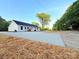 An inviting home featuring a crisp white exterior with a freshly paved concrete driveway and ample space for parking at 296 Tram Rd, Lancaster, SC 29720