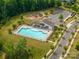Aerial view of a community pool, clubhouse, playground, and parking, all surrounded by trees and landscaping at 3017 Winged Teal Ct, Belmont, NC 28012