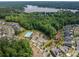 Aerial view of community and lake featuring neighborhood pool and wooded areas at 3017 Winged Teal Ct, Belmont, NC 28012