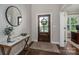 Elegant foyer with a wooden front door, marble-topped console table, and a round mirror at 3017 Winged Teal Ct, Belmont, NC 28012