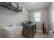 Well-equipped laundry room with modern washer and dryer, sink, and shelving at 3017 Winged Teal Ct, Belmont, NC 28012