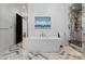 Elegant bathroom featuring a freestanding soaking tub, marble floors, gold fixtures, and stylish artwork at 3209 Mayfield Ave # 11, Charlotte, NC 28209