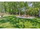 Expansive backyard with mature trees, a fire pit area, and lush green lawn, perfect for outdoor enjoyment at 323 Richmond Rd, Salisbury, NC 28144