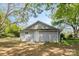 A gray home with a white door and siding is surrounded by greenery in the backyard at 4304 S Falls St, Gastonia, NC 28056