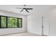 Bright bedroom featuring large windows with a treeline view, ceiling fan, and modern trim at 4377 Kiser Island Rd, Terrell, NC 28682