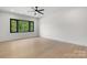 Bright bedroom with hardwood floors, modern ceiling fan, and black trimmed windows revealing a wooded view at 4377 Kiser Island Rd, Terrell, NC 28682