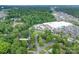 Aerial of the home's neighborhood with a lush tree canopy and showing nearby businesses and highways at 4920 Raymond Pl, Charlotte, NC 28205