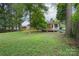 View of the home's backyard with an expansive lawn, patio furniture and a lush tree canopy at 4920 Raymond Pl, Charlotte, NC 28205