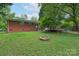 Picture of the backyard showing a fire pit, patio, brick home exterior, and a lush lawn at 4920 Raymond Pl, Charlotte, NC 28205
