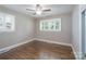 Well-lit bedroom with hardwood floors, a ceiling fan, and large windows offering ample natural light at 4920 Raymond Pl, Charlotte, NC 28205