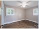 Bright bedroom featuring hardwood floors, fresh paint, windows with blinds, and a ceiling fan at 4920 Raymond Pl, Charlotte, NC 28205