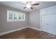 Bright bedroom featuring hardwood floors, built-in closet, and natural light from shuttered windows at 4920 Raymond Pl, Charlotte, NC 28205