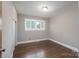 Cozy bedroom with a large window, closet, and hardwood floors creating a comfortable atmosphere at 4920 Raymond Pl, Charlotte, NC 28205