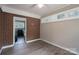 Neutral room showcasing brick accents, vinyl flooring, and natural light from large windows at 4920 Raymond Pl, Charlotte, NC 28205