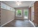 Inviting room with brick accents, a window, and access to the backyard through a glass door at 4920 Raymond Pl, Charlotte, NC 28205